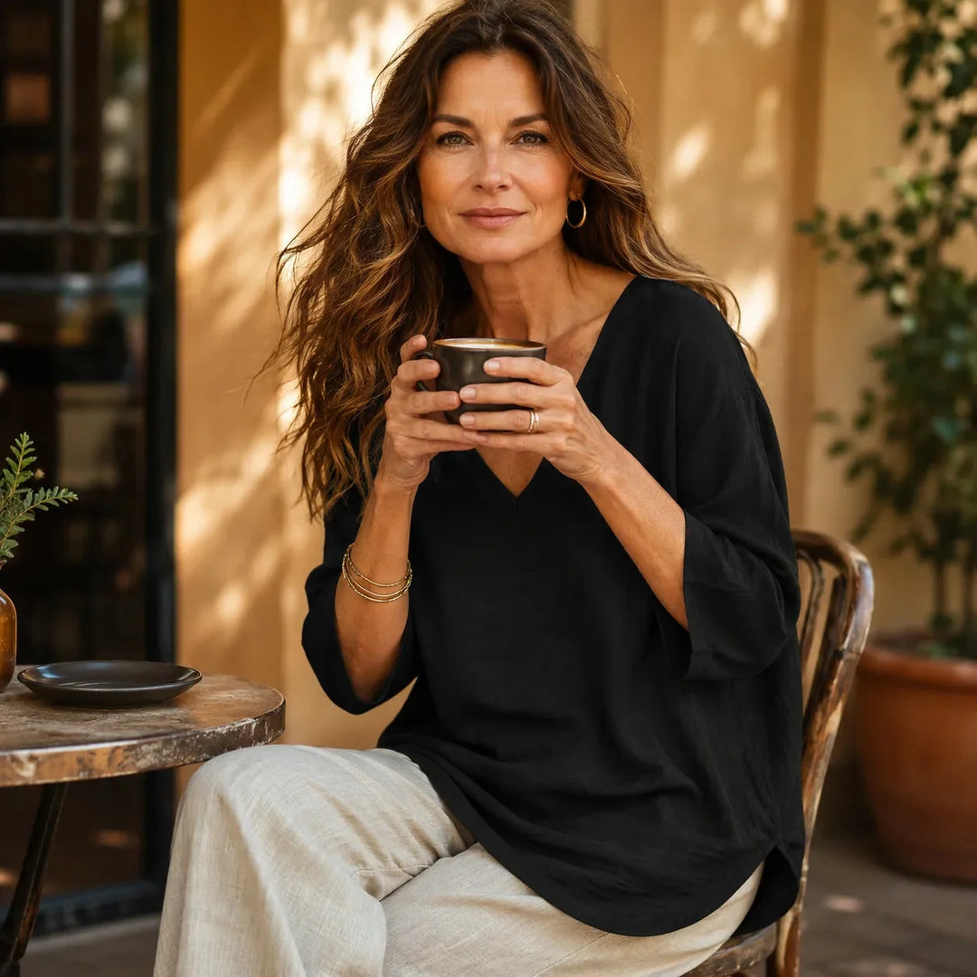 Black Women's V-Neck Linen Blouse — Elise Curved Hem Three-Quarter Sleeve Relaxed - Seated Lifestyle